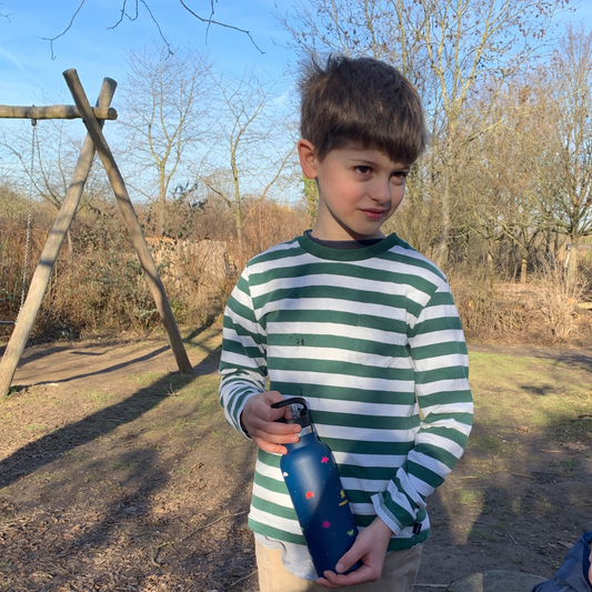 Kind hält KiNDKiT Power Up Trinkflasche 500ml dunkelblau im Freien